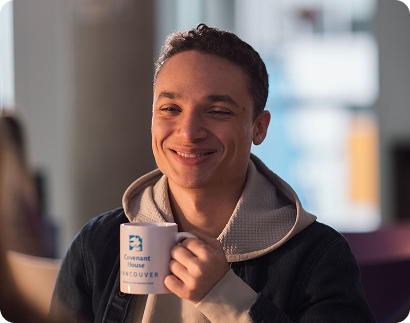 Young person holding a Covenant House Vancouver mug